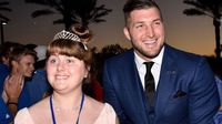 Tim Tebow e uma convidada de honra caminham de mãos dadas pelo tapete vermelho na "Noite para Brilhar" de 10 de fevereiro de 2017. (Fundação Tim Tebow)