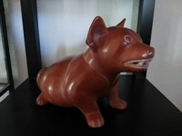 Perro de la raza Tlatchichi o Techichi, que representa a la deidad de la mitología mexicana y tolteca del ocaso Xólotl, que sirve de alimento para consumo humano y ayuda a cruzar a las almas el río Itzcuintlán para llegar al Mictlán, la tierra de los muertos