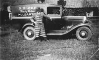 Oliver Blackburn with Sam Blake's butcher's van outside his mother's old thatched cottage by Mulbarton Church