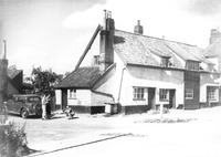 Corner of B1113 & East Carleton Road: we believe the barber's shop was through the doorway behind the person crouching with a dog.