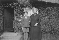 Laurence Bailey (b.1920) as a boy with his grandmother, Mrs Hemnell, outside their cottage (late 1920s)