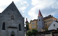 Věž zvonice ve Stráži nad Nežárkou je dnes schovaná za mnohem mladší žlutou budovou školy