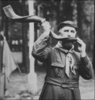 Le Père Sevin appelant au rassemblement dans la corne de koudou offerte par Baden-Powell