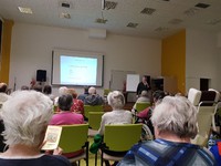 uživatelé sledující přednášku ve společenském sále domova