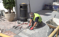 Operario trabajando en la puesta de adoquines de calle Carmen