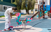 Operario pintando los parques infantiles de Nerja