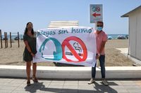Verónica Muños y Óscar Medina posan con la bandera de 'Playas sin Humo'