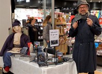 Fra en boksignering i desember 2018. Petrus Jensen har fått laget en av de mystiske tøydukkene i full størrelse, og han snakker gjerne med kundene, lettere utkledd som Sherlock Holmes med både krumpipe og forstørrelsesglass!