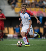 Kuva 2: Suomen Jaakko Oksanen hyödyntämässä peruspelaamisen minitaidoista kuljettamista Suomessa järjestetyissä U19-poikien EM-kisoissa 2018. Kuvan oikeudet: Jussi Eskola.