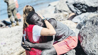 Luna, de 20 años, consolando a un migrante tras cruzar la frontera entre Marruecos y España en Ceuta, 19 de mayo de 2021. Twitter @CruzRojaEsp