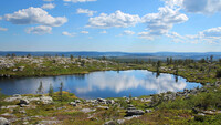 Pequeño estanque que refleja el cielo azul y las nubes blancas sobre la cima de Särkitunturi Fell en Muonio, Laponia, Finlandia. Shutterstock