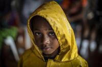 UNICEF/UN0372373/Ocon/AFP-Services Una niña se protege de las fuertes lluvias con un impermeable al regresar a casa desde un refugio tras el paso del huracán Iota en Nicaragua, en Bilwi, el 16 de noviembre de 2020.