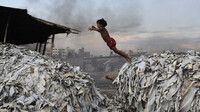 Un niño salta sobre desechos en Hazaribagh, Dhaka, Bangladesh, 9 de octubre de 2012. Andrew Biraj