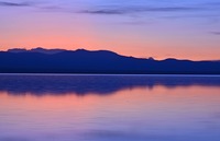 Een kleurrijke hemel weerspiegeld in een meer in Salar de Uyuni, Bolivia.